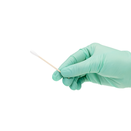 Gloved hand holding sample of cotton tip applicator