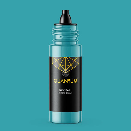 A bottle of Quantum tattoo ink Skye Fall a True Cyan color Ink, featuring a black label and dropper cap with a gold geometric logo and text, and a translucent teal body, set against a solid teal background.