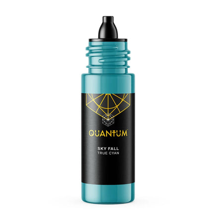 A bottle of Quantum tattoo ink Skye Fall a True Cyan color Ink, featuring a black label and dropper cap with a gold geometric logo and text, and a translucent teal body, set against a solid white background.
